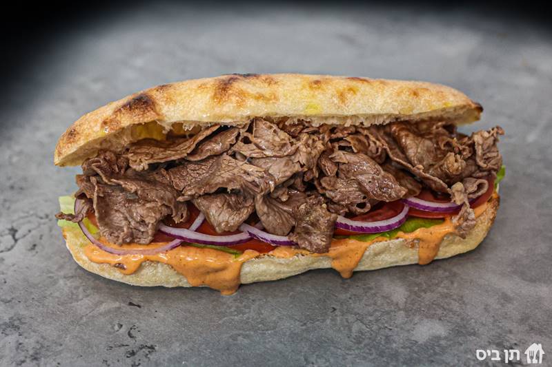 סלייסים של אנטריקוט, עם מגוון ממרחים וסלטים לבחירה מגיע לצד חמוצים צהובים וטחינה	