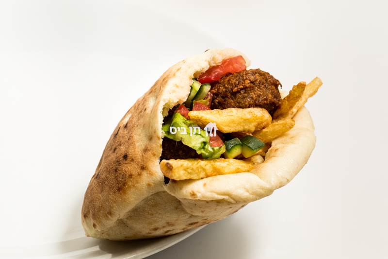 שיפוד פרגית בפיתה, מוגש עם מבחר סלטים לבחירה 
