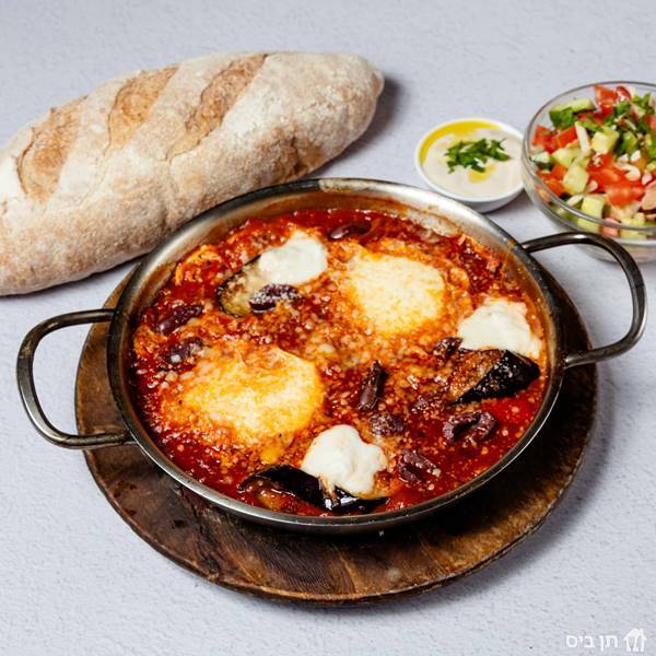 שקשוקה איטלקית, שקשוקה עם חצילים, זיתי קלמטה, גבינת פטה, בזיליקום ופרמז'ן. מוגש עם סלט קצוץ ולחם הבית