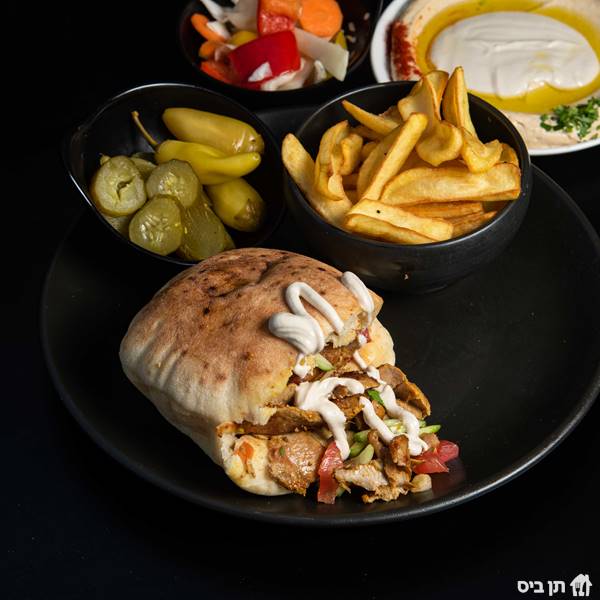 שווארמה בפיתה, מוגש עם מבחר סלטים לבחירה