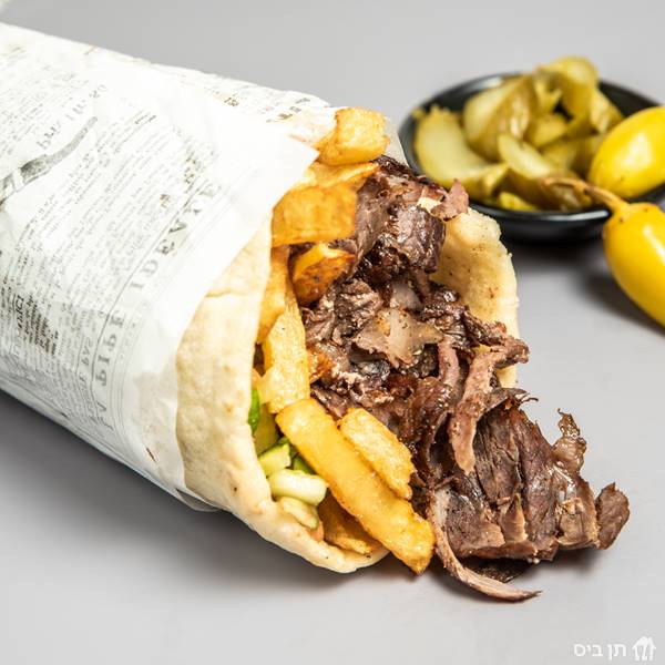 שווארמה עגל בלאפה, שווארמה עגל עסיסית בלאפה מוגש עם מבחר סלטים לבחירה וחמוצים.	